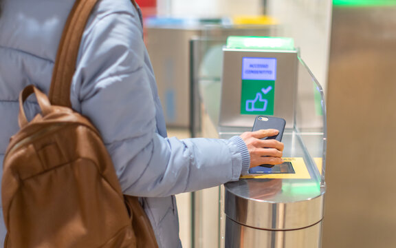Electronic Boarding pass and passport control in the airport - hand with boarding pass on smartphone at the turnstile.