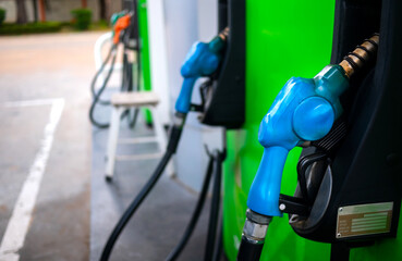 Fuel oil gasoline dispenser at petrol filling station.Holding fuel nozzle to refuel gasoline for car.