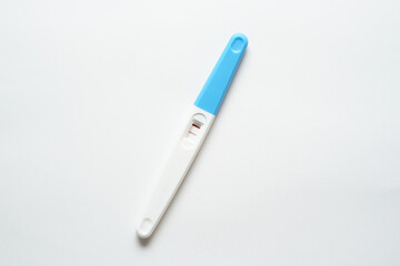 Pregnancy test pack hold by hand on top of white background.