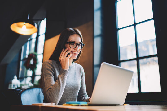 Cheerful Female International Student Checking Email Box Reading Message From University Enrolled Her To Journalism Course Without Examination Testing While Talking On Phone With Friend Greeting