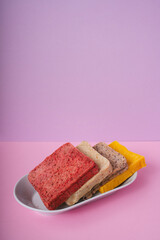 Four colourful Home made organic sliced bread on a plate in purple pink room.