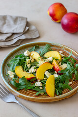 Salad with peach, arugula, cheese, nuts and honey. Healthy eating. Vegetarian food. Recipe.