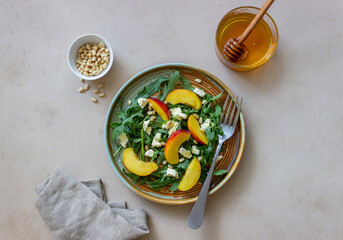 Salad with peach, arugula, cheese, nuts and honey. Healthy eating. Vegetarian food. Recipe.