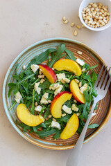 Salad with peach, arugula, cheese, nuts and honey. Healthy eating. Vegetarian food. Recipe.