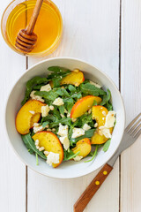 Salad with peach, arugula, cheese, nuts and honey. Healthy eating. Vegetarian food. Recipe.