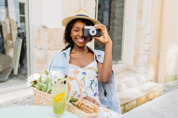 Outdoor summer lifestyle portrait of excited african woman having fun in the city. Female...
