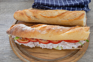 sandwich au thon et crudités sur une planche à découper