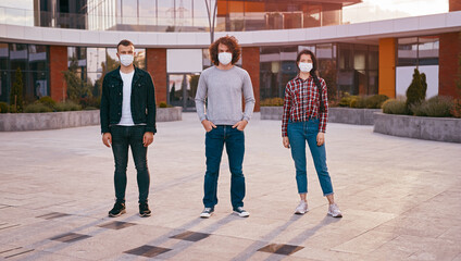 Young colleagues in masks on street