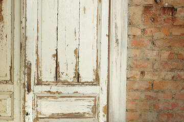 Old, white painted doors, closed, indoors with red brick wall