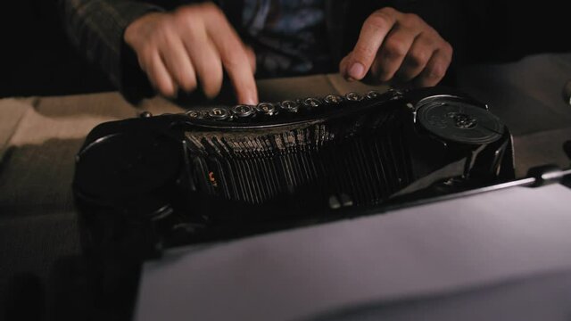 4k. Hands typing a film script or a book on a vintage typewriter. Close-up of hands typing on a vintage typewriter.