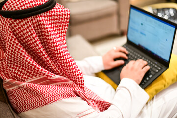 Arabic man from Saudi Arabia working at home to protect him self from the viruses pandemic COVID-19...