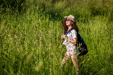 Girl with a backpack in the field.