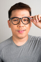 Face of happy young handsome Asian man wearing eyeglasses