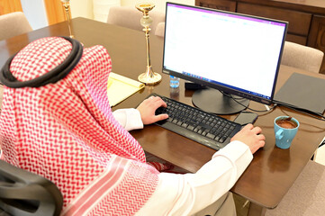 Arabic man from Saudi Arabia working at home to protect him self from the viruses pandemic COVID-19...