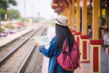  Young asian gril walking at train station before travel. work and travel concept.