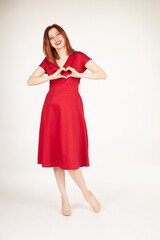 Smiling redhead girl on white background red dress