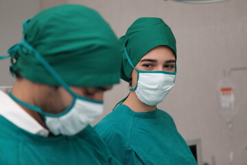 Fototapeta na wymiar surgeons team wearing safety masks performing operation. Medicine concept