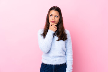 Young Colombian girl over isolated pink background thinking an idea