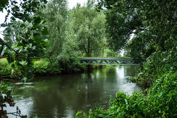 Fototapeta na wymiar View of the bridge over river Dommel. Colorful landscape park with beautiful trees and water in provinces Noord Brabant, the Netherlands.