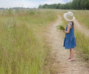 Foto op Canvas Little girl with bouquet of chamomiles looks away towards the horizon © Albert Ziganshin