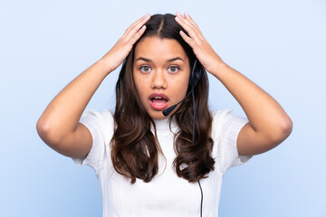 Young telemarketer Colombian woman over isolated blue background with surprise facial expression