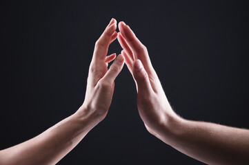 A close-up of two hands male and female gently touch each other. The concept tremulous rejection...
