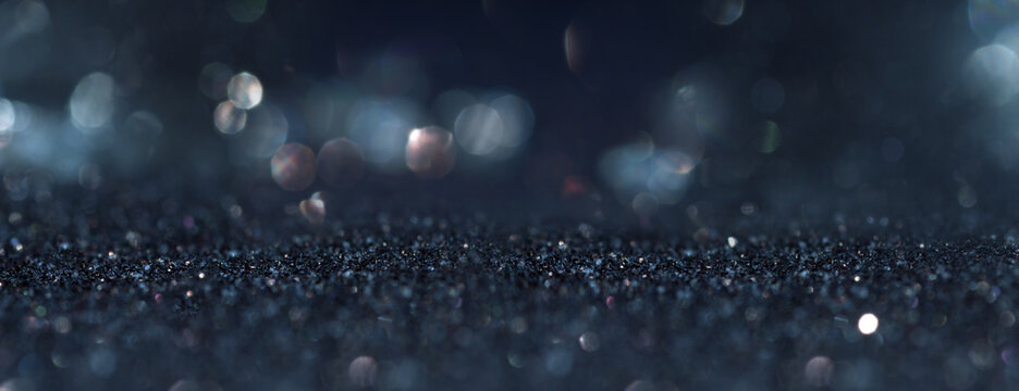 Abstract dark blue background with blurred silver bokeh. Horizontal background with short depth of field for religious rituals and spiritual meditation or grief.