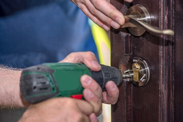 Men repairing a door using a drill