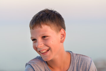 Portrait of a smiling boy, close-up, tan, evening shot.