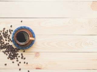 Hot coffee on wood with coffee beans.