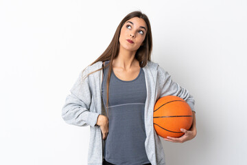 Young woman playing basketball isolated on white background and looking up