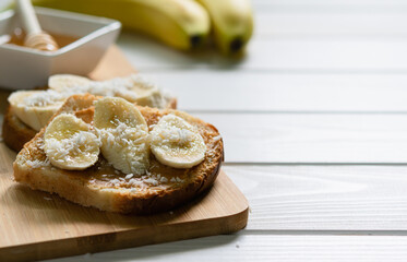 fast food, snack, peanut butter, banana and honey sandwich on a white wooden table, free space for writing text