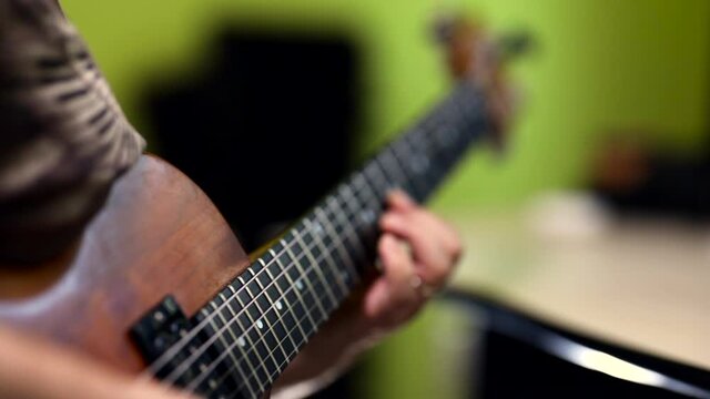 Close-up of a man playing a vintage 1978 brown electric guitar