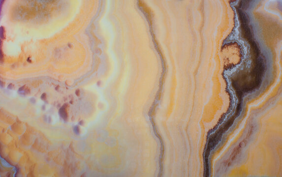 Cream gold natural onyx with brown stripe texture close up