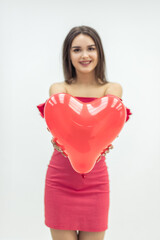 Lovely girl fell in love and expresses her tender feeling giving a heart balloon to her lover.