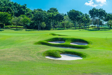 A beautiful view landscape in morning time green grass at golf course ,big trees, sand bunker and mist with sunlight rays background.