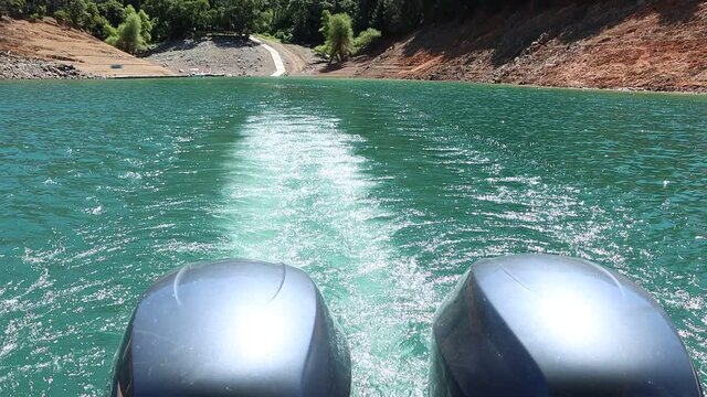Water boils out from twin outboard engines at the back of a boat at Lake Shasta slow motion
