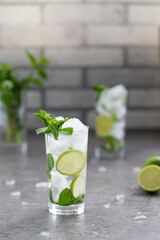 Mojito cocktail with lime and mint in glass. Mojito cocktail on dark stone table, selective focus.