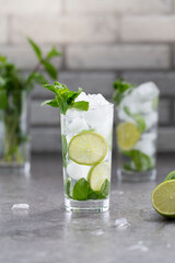 Mojito cocktail with lime and mint in glass. Mojito cocktail on dark stone table, selective focus.