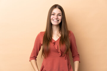 Obraz premium Young caucasian woman isolated on beige background laughing