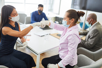 Two business women greet each other with a fist