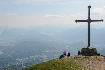 People at cross of Motto on Capriasca velley over Lugano in Switzerland