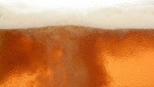 Close up background of beer with bubbles in glass