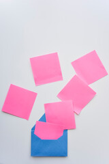 selective focus, pink paper stickers in chaos and blue envelope on the white background