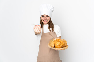 Young woman in chef uniform isolated on white background inviting to come