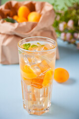 Summer cold drinks homemade apricot lemonade ice tea with ice cubes and mint