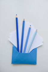 selective focus, blue pencils and white papers out of the blue envelope