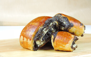  poppy seed Roll on a wooden surface, closeup , selective focus, blurred background       