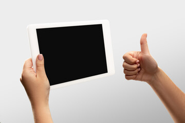 Thumb up, like. Close up female hands holding tablet with blank screen during online watching of popular sport matches, championships. Copyspace for ad. Devices, gadgets, technologies concept.