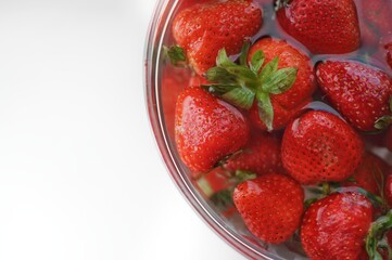 Summer fruits top view. Home strawberry in bowl with water with copy space